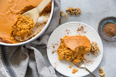 plate of sweet potato souffle with a casserole dish of sweet potato souffle