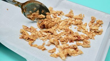 Baking coconut chips to make coconut bacon.