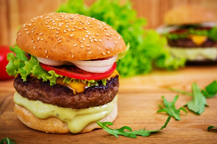 Delicious handmade burger on wooden background. Close view